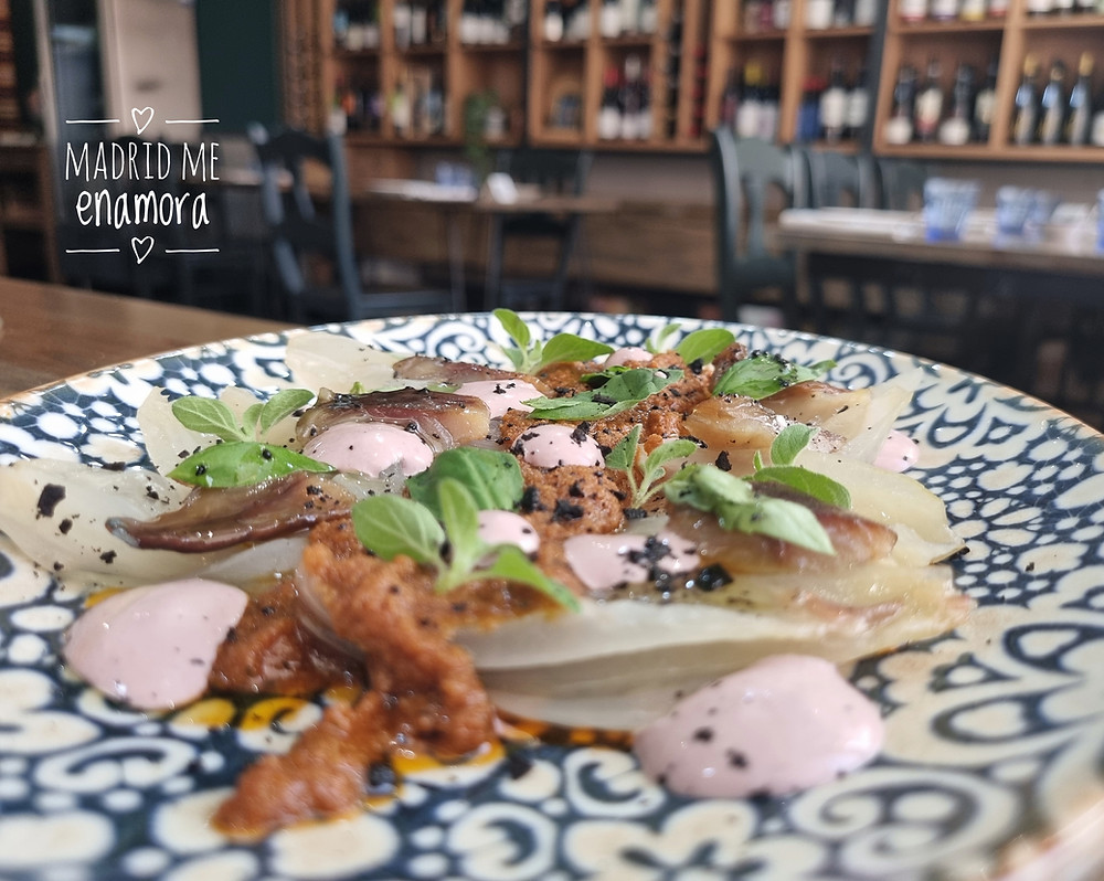 Cebolla asada con arenque ahumado, tapenade de aceituna negra y mayonesa kalamata.