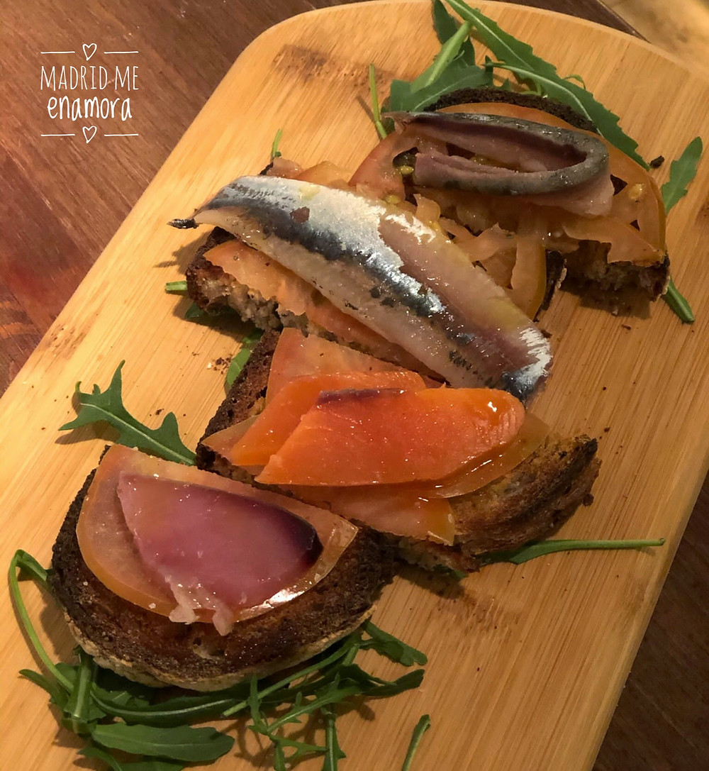 Semisalazones de bonito, sardina, caballa y salmón presentados en una tosta con tomate rallado.