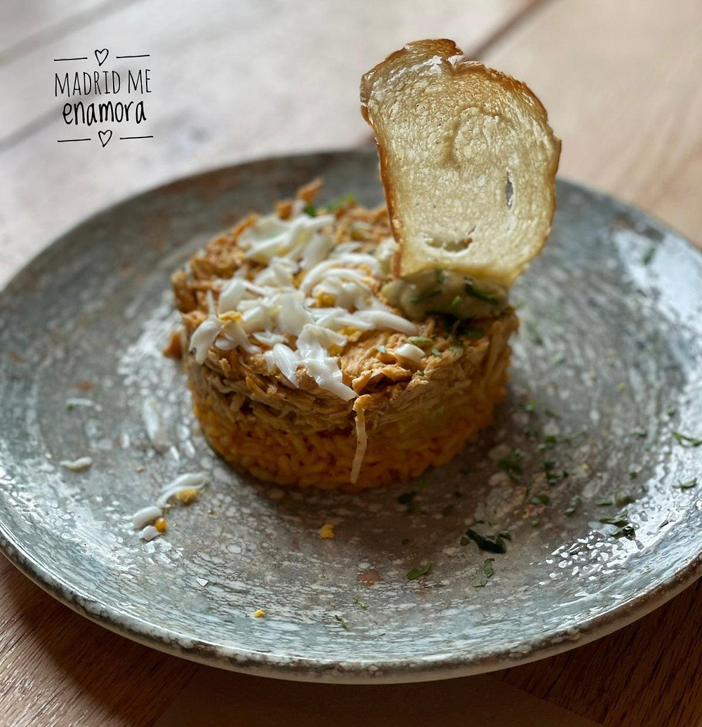 Seco de gallina al estilo andino con arroz achiotado, mimosa de huevo y guacamole.