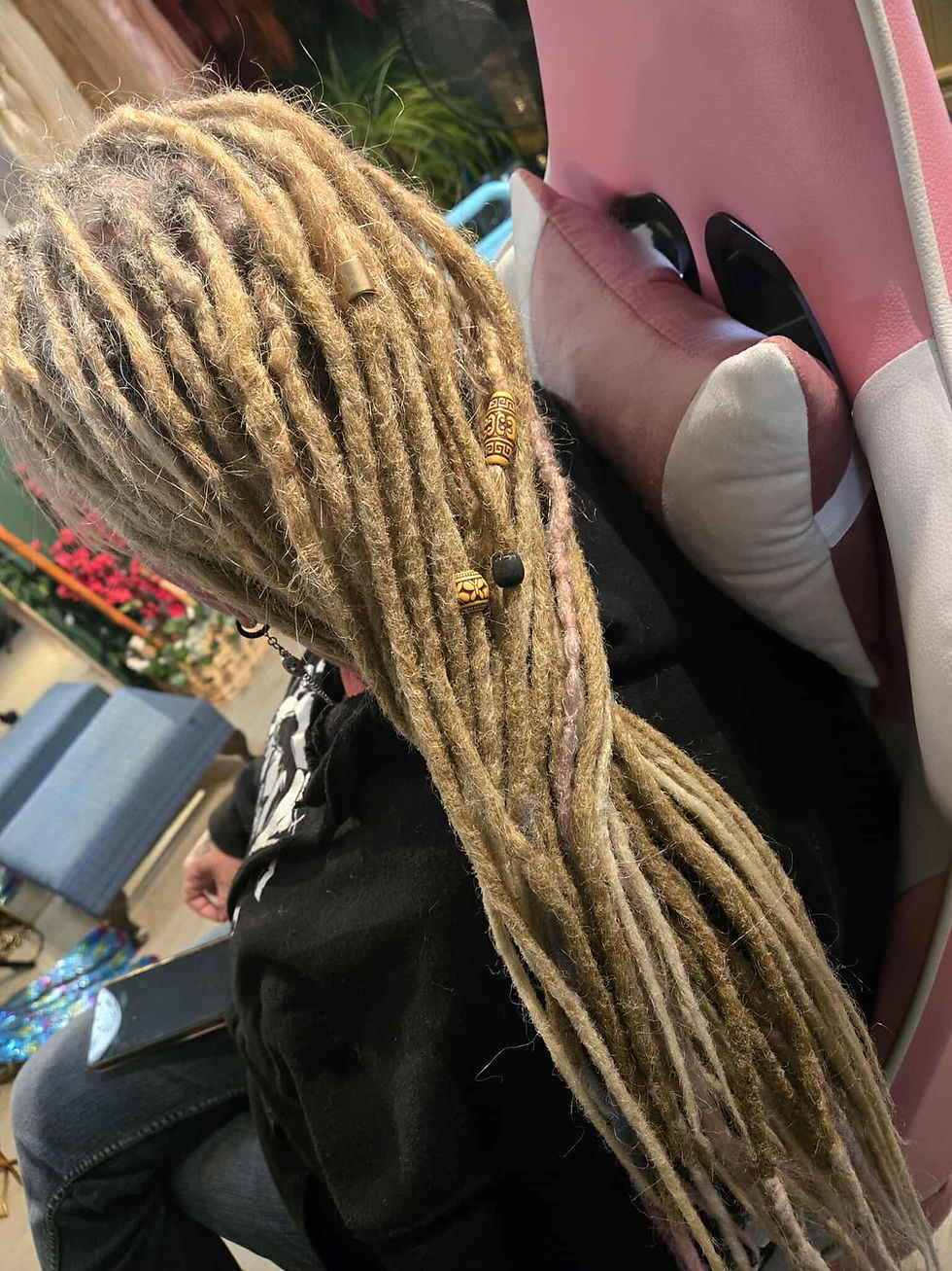 A woman with blonde natural dreads receiving a dread refresh.