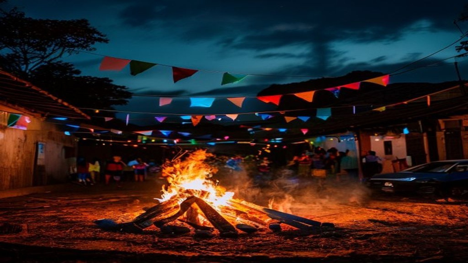 Fogueira de festa junina acesa à noite com bandeirinhas coloridas ao fundo, ambiente de arraial no Sul do Brasil, sem rostos identificáveis — Camaquã