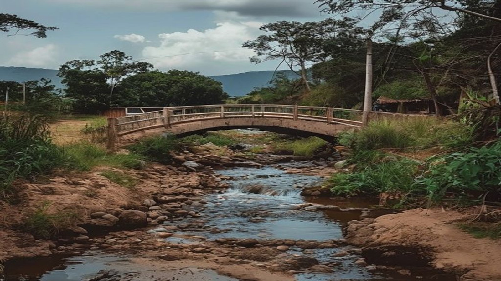 Ponte rural de concreto sobre arroio em estrada de terra no interior do Sul do Brasil, vegetação ao redor, sem pessoas — Sertão Santana, Tapes