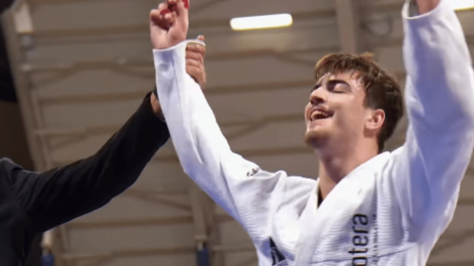Atleta de jiu-jitsu de kimono azul em tatame durante competição, em momento de vitória, sem rosto identificável em close — Camaquã, Camaquã/Costa Doce