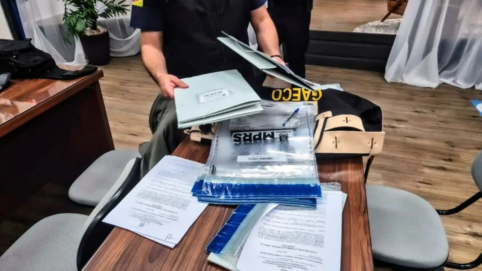 Relógio de ponto eletrônico em parede de repartição pública, corredor institucional vazio, sem pessoas — Guaíba, RS
