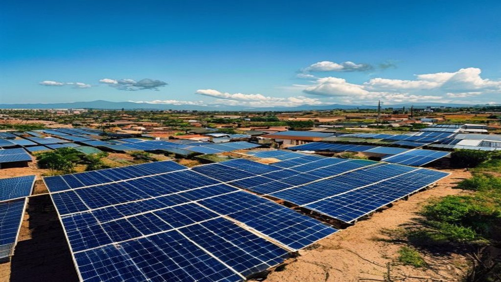 Vista ampla de fileiras de painéis solares fotovoltaicos sob céu azul no interior do Rio Grande do Sul, sem pessoas — UFSM, Santa Maria/RS