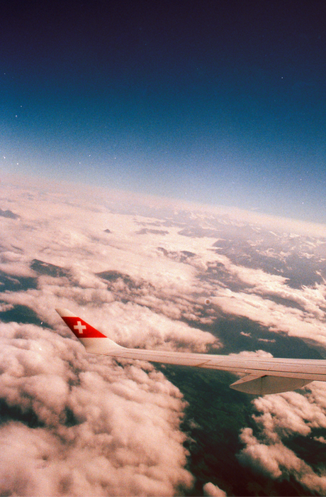 Aerial travel photography clouds and Swiss airline wing Studio Barco