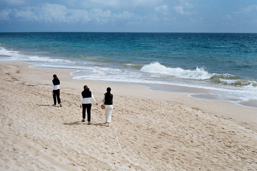 Authentic travel photography people walking on sandy beach Studio Barco