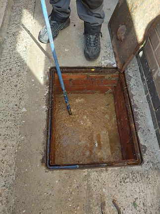 man standing next to blocked drain