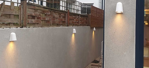 Modern garden concrete wall featuring a row of stylish white outdoor wall up and downlights