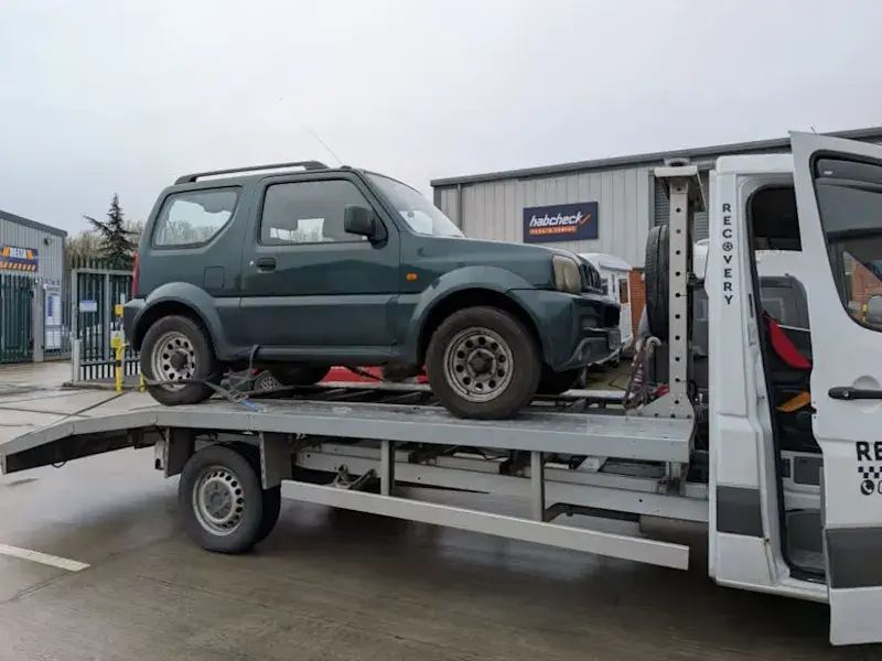 Tow truck operator takes photo of a car before loading it onto the truck.