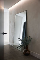 a living room with a very large mirror against a wall