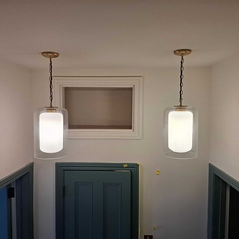 Pair of elegant glass pendant lights with textured white diffusers hanging from chains