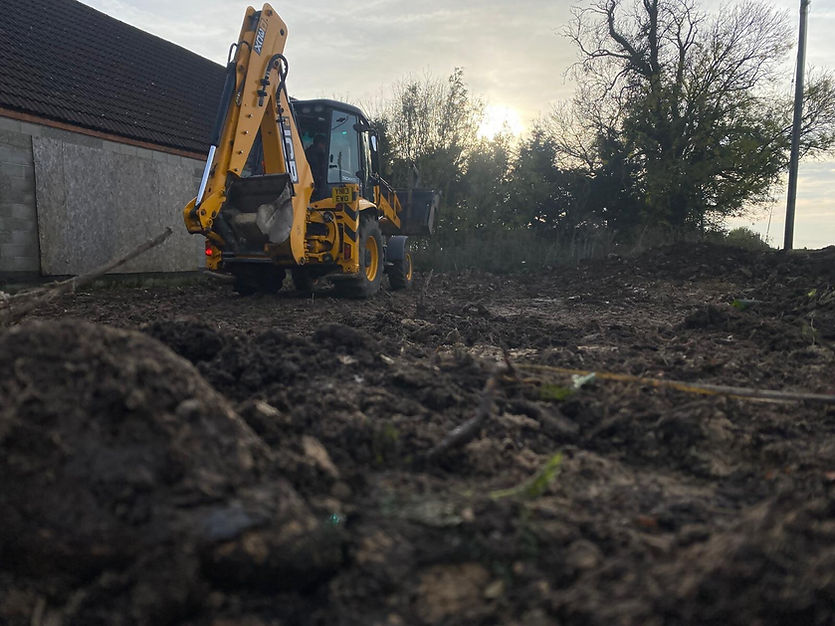 Digger on patch of dirt during sunset