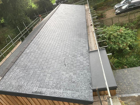 An overhead view of a long rooftop with newly installed grey bricks