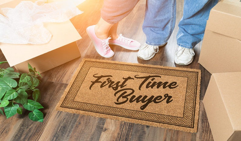 Feets of a couple standing above a door mat which has first time buyer written on it | Rriddhi Siddhi properties