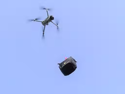 A drone carrying a payload with a payload release and drop device attached to its bottom from Drone Sky Hook with a clear blue sky visible in the background