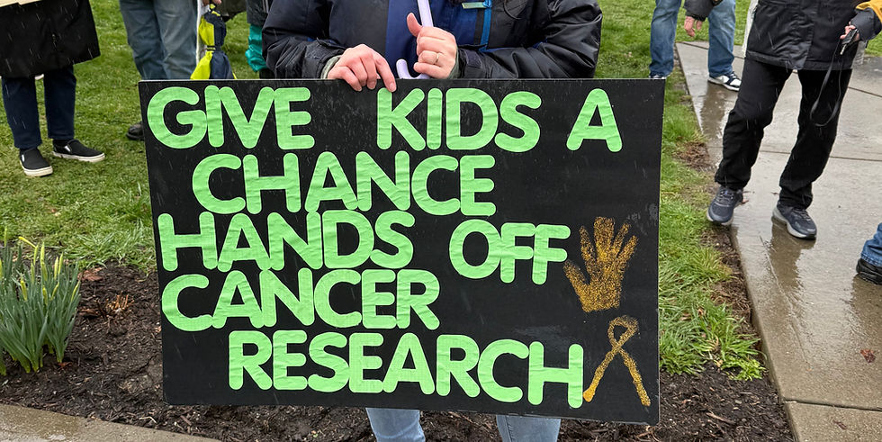 Protest sign reading "give kids a chance, hands off cancer research"