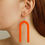 Thumbnail: acrylic u-shaped dangle earrings beign worn by a female model