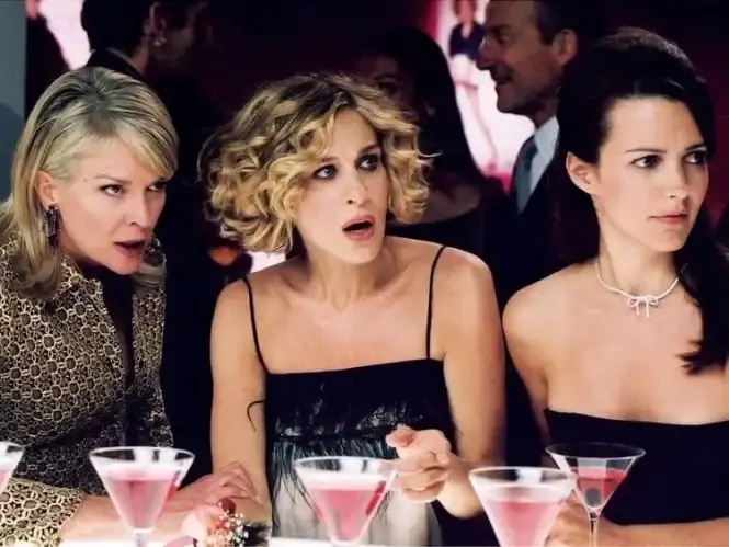 The cast of sex and the city with a selection of cosmopolitan cocktails on the bar in front of them.