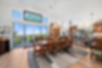 Dining area with large windows, sliding glass doors to view deck, vaulted ceiling, and open kitchen layout
