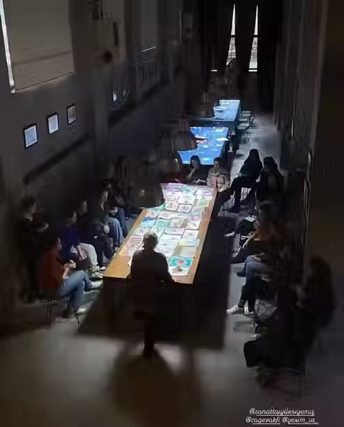 Sanat terapisi atölyesinde masanın etrafında çalışan katılımcılar