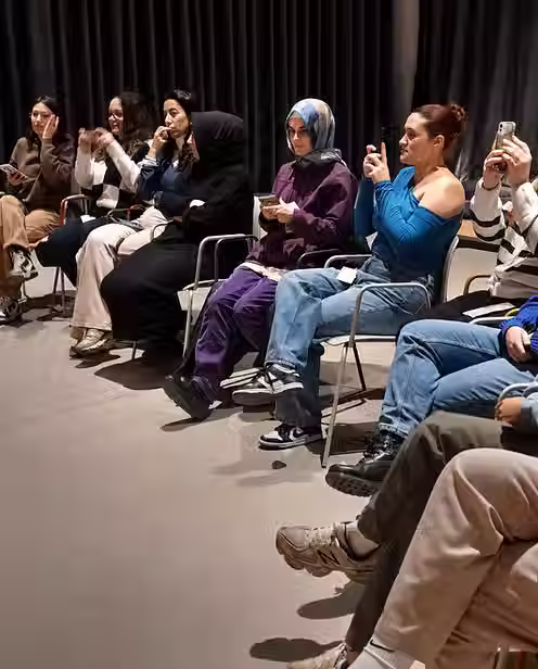 Müze odaklı sanat terapi atölyesinde yan yana oturan katılımcılar.