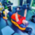 A client performing a dumbbell chest press while on the half peanut ball.