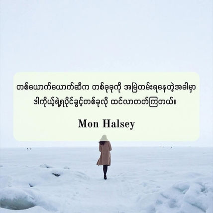 A person in a tan coat and hat walks on a snowy landscape. Text in Burmese and "Mon Halsey" is overlaid on the image. Peaceful mood.