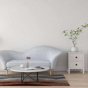 Minimalist room with a gray sofa, round table, and plant. A lamp stands on a wooden floor, and a patterned rug adds contrast. Calm vibe.