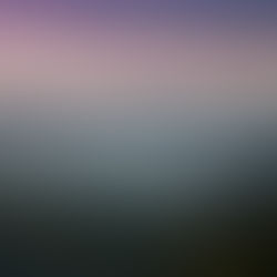 Mountain landscape at sunset with layered hills and a purple-pink sky. Text in a foreign script overlays the image. Calm and serene mood.