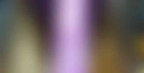 Tall building lit in purple towers over a crowd at night. Colorful Christmas tree below. Text: Rockefeller Center, New York.