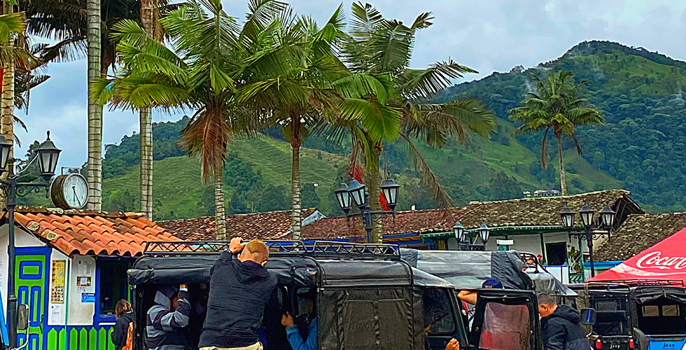 People boarding a black jeep in Salento, Colombia, with palm trees and mountains in the background. Overcast sky. Text: Salento location details.