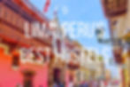 Street in Lima with colourful buildings, ornate balconies, and people walking. Text: "Lima, Peru's Best Hostels." Bright day mood.