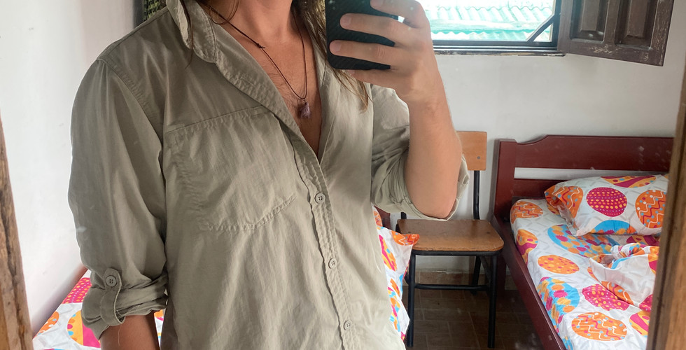 Man in mirror takes selfie showing the essential amazon rainforest clothing he is wearing 