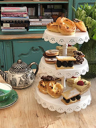 The Mad Hatters Tea Party might be famous in literature, but Carol’s high teas are famed across Somerset.

You will have a mad day out making some magically wonderful and scrumptiously delectable treats to showcase the British tradition of afternoon tea. Carol was most recently the Head baker at Hestercombe Gardens in Somerset for three years. Before that she designed and made all the puddings at The Firehouse Somerset with Miranda. According to our guests these puddings were unbelievable. So, we do have some kudos when it comes to making an excellent dessert or four.  We have put all our knowledge and skill together to bring this Afternoon Tea Course to fruition and we are very proud of the results.

Did you know that there is a difference between and Afternoon Tea and High Tea?

The British tradition of afternoon tea was introduced by Anna, the Duchess of Bedford, became fashionable in the 19th Century and was the preserve of the rich. You can thank this duchess for the excuse to sit down for an afternoon treat of tea, sandwiches, scones and cake. Never the intention to stuff oneself silly, so one couldn’t move, this was just to fill the long gap between lunch and dinner at a time when dinner was served at around 8pm.

Workers in newly industrialized Britain, had to wait until they had finished work to enjoy teatime. Tea was served later and consisted of much heartier dishes rather than tea and cake. The after-work meal was usually hot and filling, and to revive flagging spirits was accompanied with a pot of strong tea. This tea was served at the table and workers were seated on high back dining chairs. It is believed that the word ‘high’ distinguishes the two types of tea, as afternoon tea is traditionally served to those relaxing in the garden or on low comfortable chairs in the parlour.

Surrounded by stoves that originated in the 19th century such as the Esse Ironheart, we will teach you how to bake a traditional afternoon tea. Using some original recipes and a few with a more modern twist, we aim to recreate a slice of history which we hope would gain the approval at court of the Duchess of Bedford or perhaps even Marie Antoinette.

You will bake your own traditional Artisan loaf to make finger sandwiches with two types of filling. You will learn how to make blackberry and apple fancies and lemon and vanilla Magdalenes. We will make a traditional tea loaf or fruit cake, some of our signature scones and jam from our Bread and Jam Course. There will always be a little chocolate something to feast on too. So, get the girls (and guys if they like a bake off) together, find a reason to have a day out and book on to this course. You will have a wonderful afternoon tea to enjoy around our farmhouse table after a good day’s baking.

Lunch included
Price: £200 per person
Course limited to 4 people
Enquire with Miranda on 07899665635. Dates must be agreed and booked in advance.