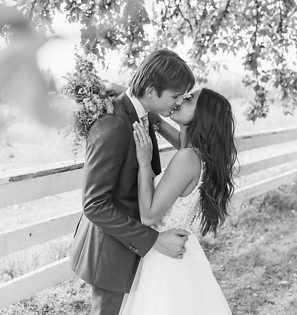 newly married couple kissing under tree