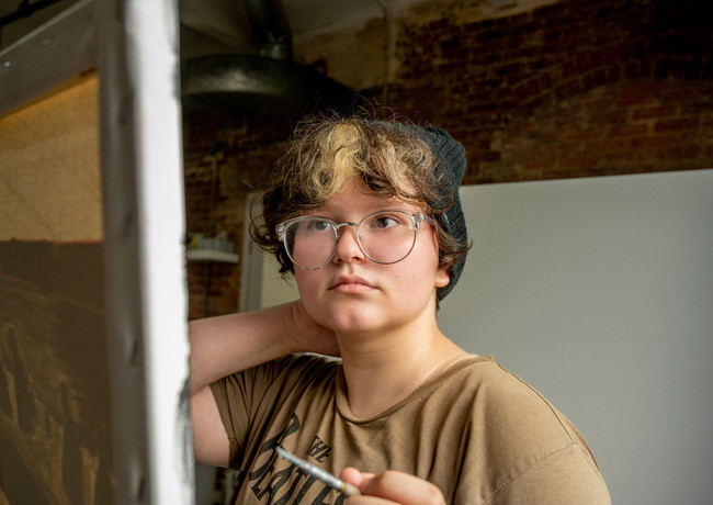 high school senior looking at their painting contemplating