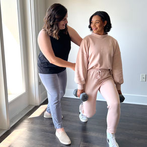 Physical therapist providing hands-on support to a patient during a lunge exercise in a clinic setting.