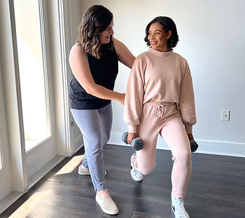 Physical therapist providing hands-on support to a patient during a lunge exercise in a clinic setting.