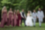 4 Brautjungfern im roten Kleid, in der Mitte Braut und bräutigam, rechts zwei Männer in grauen Anzügen