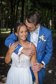 Bräutigam steht hinter Braut, Bräutigam umarmt Braut