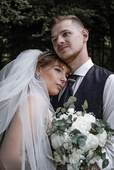 Braut lehnt sich an Bräutigam