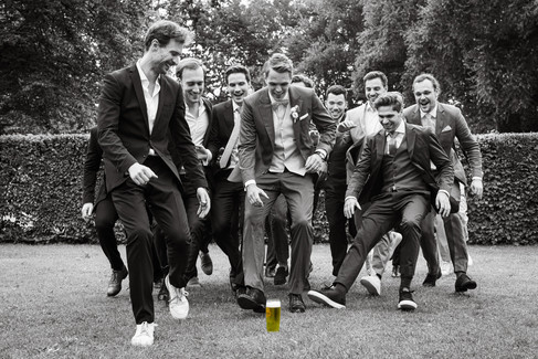 schwarz weiß Bild, Männer laufen zum Bierglas, Bierglas steht auf Rasen
