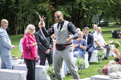 Blumenboy wirft Rosen, Menschen sitzen und stehen drumherum