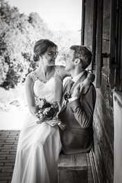 schwarz weiß Bild, Braut sitzt auf Schoss von Bräutigam, schauen sich an