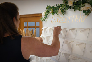 weiße Loveletter Wand mit Frau, nimmt sich Loveletter aus Briefumschlag