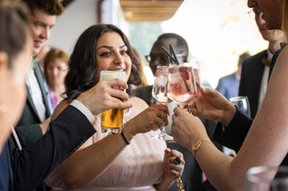 Frau stößt mit anderen an, Bierglas und 3 Cocktailgläser
