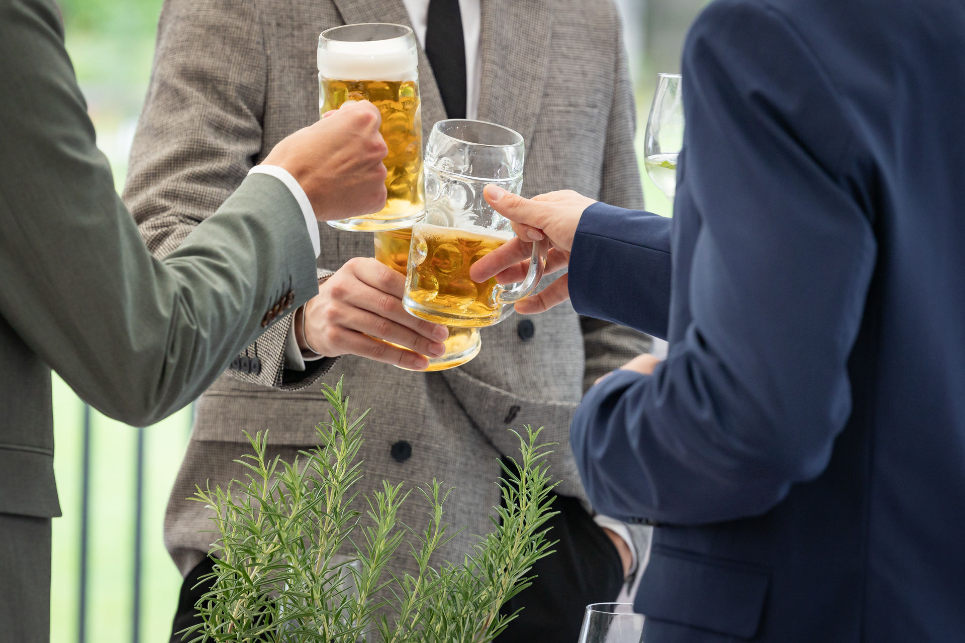 drei Biergläser werden angestoßen