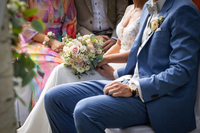 Brautstrauß auf Schoß von Frau, Männerhände, Frauenhände, Hände halten sich fest