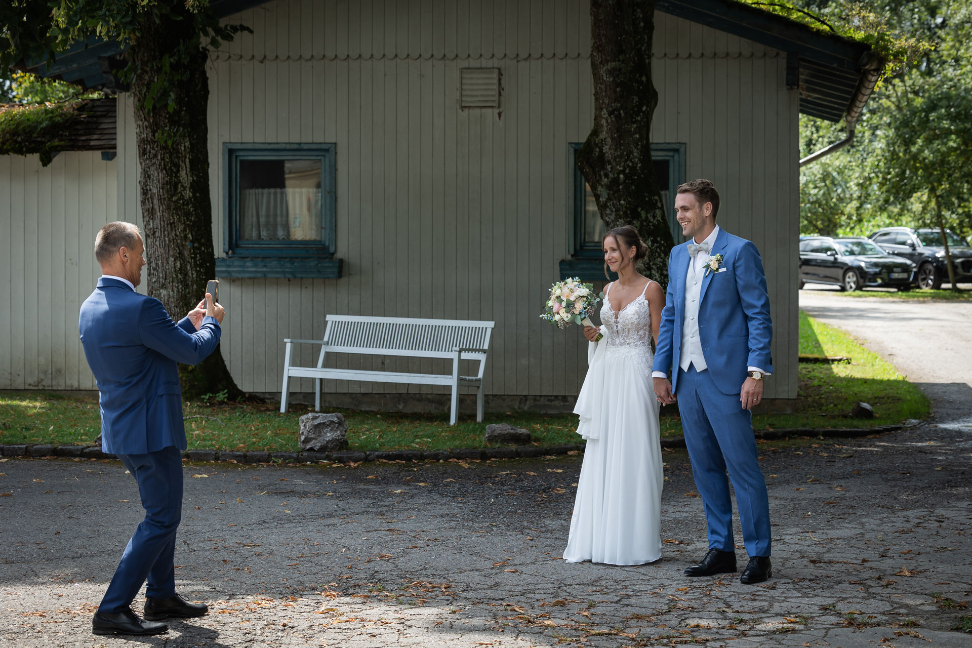 Mann fotografiert Brautpaar mit Handy